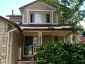 Two-story home combining painted siding, dark trim, and natural stone