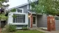 Single-story home with gray siding, white trim, and a brick entry accent