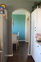 White painted kitchen cabinets beside a colorful dining area
